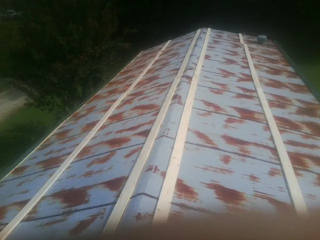 Rusted metal roof panels with new wood purlins before replacement — Storm Damage Roof Repair in Norfolk by Roofing Brothers